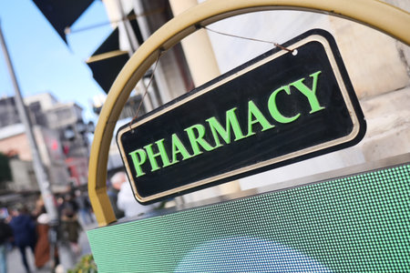 Green pharmacy sign on a busy city street in daylightの写真素材