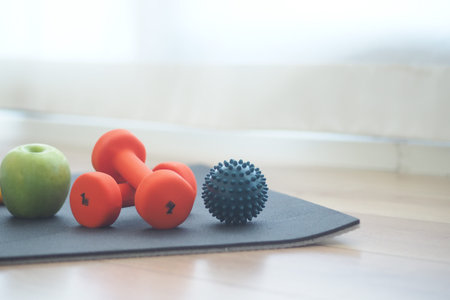 Small weights and fruit on exercise mat in living roomの写真素材