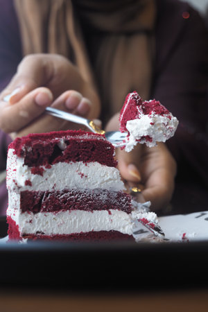 Person enjoying red velvet cake with a fork