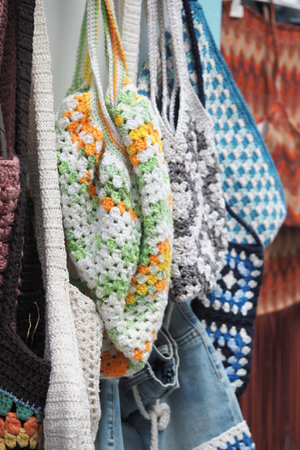 Crochet bags hanging on display at a market