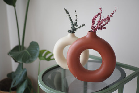 Modern vases with dried flowers on a green tableの写真素材