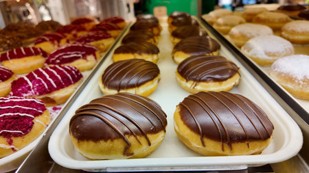 Donuts with chocolate icing and pink toppings on display