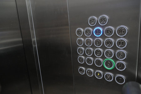 Button panel shows elevator options on a steel surface