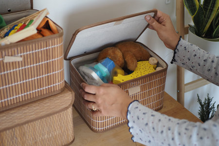 Organizing toys in storage box on a wooden table