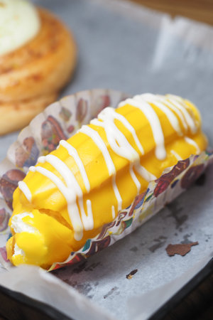 Fresh dessert with yellow topping served on paper tray