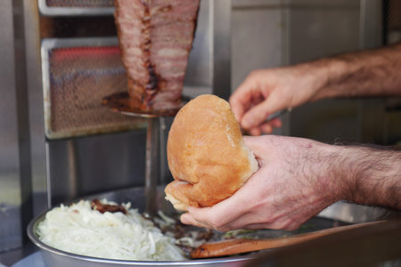 Making a sandwich with meat and bread at street food stand