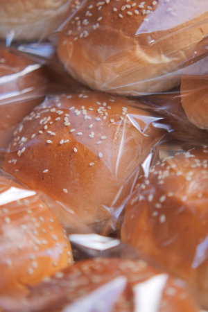 Freshly baked sesame rolls in clear packaging