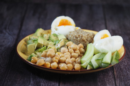 Chickpeas with avocado and eggs on a plate at dinner time