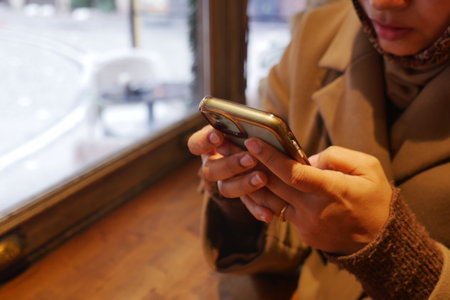 Person using smartphone in a cafe during the day