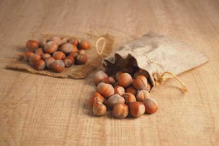 Hazelnuts on a wooden table with burlap bags