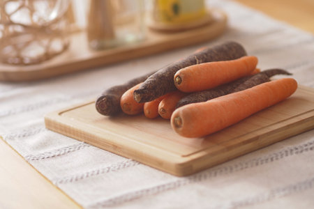 Various carrots on a wooden cutting board in a kitchen