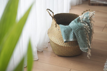 Basket with blanket near window in home settingの写真素材