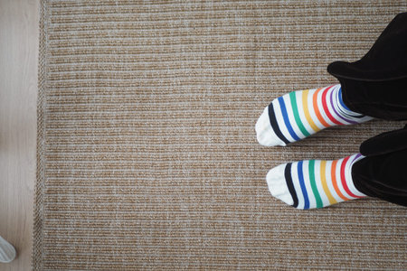 Feet in colorful socks on a rug in a home setting