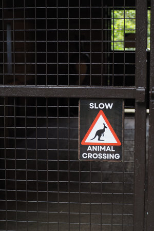 Sign warns about animal crossing in a zoo spaceの写真素材