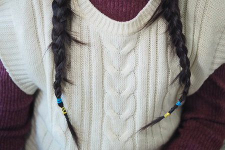 Braided hair with colorful beads in a cozy indoor setting