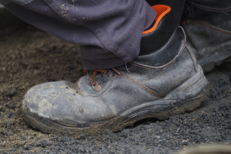 Worker puts on safety boots for construction task