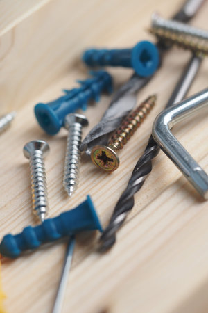 Tools and fasteners on a wooden surface in a workspace