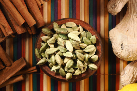 Cardamom and spices on a colorful surface
