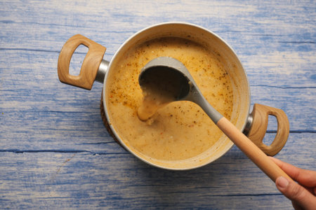 Cooking soup in a pot on a blue wooden table