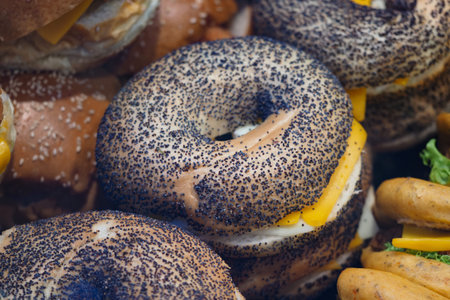 Bagels with cheese and poppy seeds are arranged on a table