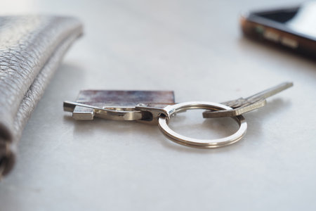 Keys and wallet on a table next to a mobile phone
