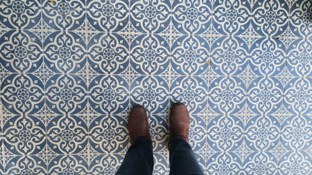 Feet on decorative tile floor in a building with patterned design