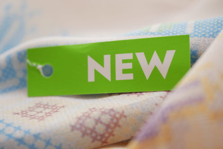 Text label shows the word new attached to colorful fabric in a close-up view