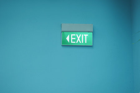 Sign showing the exit direction in a blue wall area