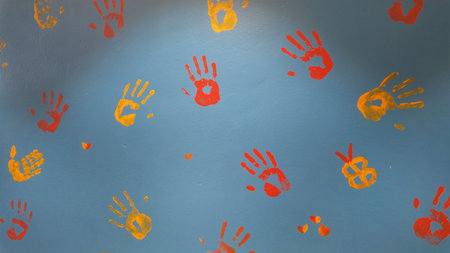 Colorful handprints on a blue wall in a creative space