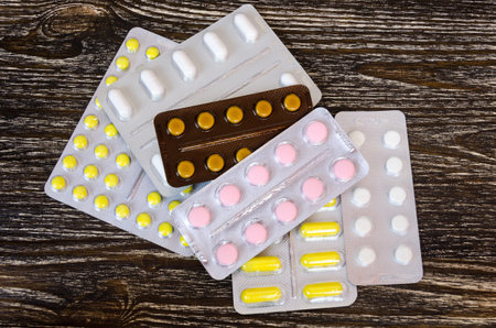a set of tablets and pills for a speedy recovery and prevention of diseases. On wood background