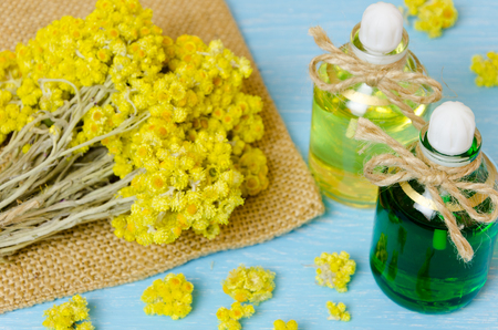 oil for aromatherapy homemade with dry flowers on wooden background.の写真素材