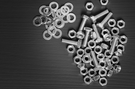 set nuts and bolts on a black wooden background