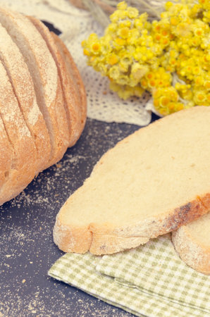 Healthy sliced homemade bread on wooden background. Toned photo