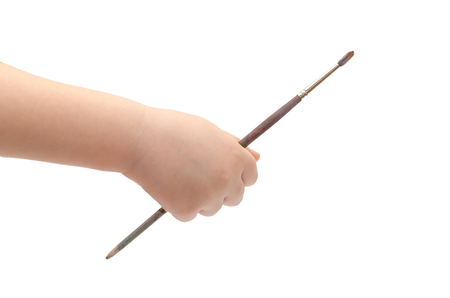 hand of young kid holding paintbrush. Isolated on white backgroundの写真素材
