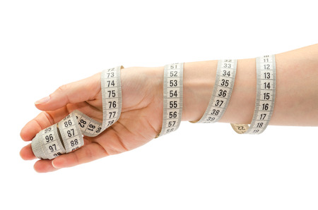 female hand holding centimeter to measure. Isolated on white backgroundの写真素材