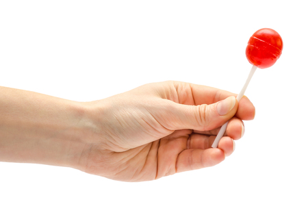 woman hand holding lollipop candy. Isolated on white backgroundの写真素材