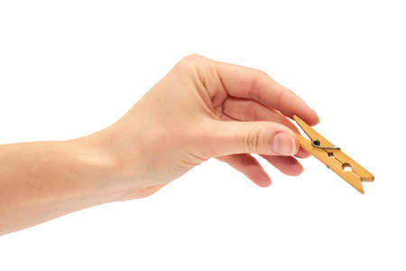female hand holding a wooden clothespin for linen. Isolated on white backgroundの写真素材