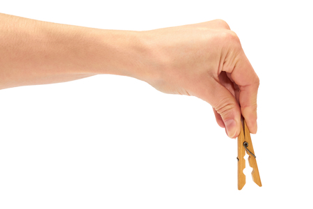 female hand holding a wooden clothespin for linen. Isolated on white backgroundの写真素材