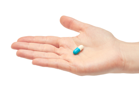 Beautiful female hand holds pill gesture. Isolated on white background.の写真素材