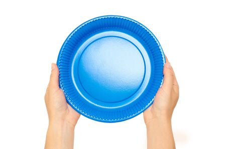 Female hands hold a cardboard or plastic disposable plate. Isolated on white background.の写真素材