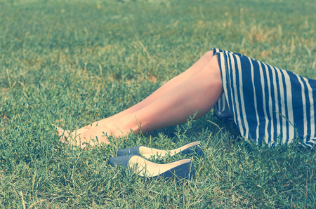 girl in skirt lying on the green grass. The concept of rest, tranquillity and relaxationの写真素材