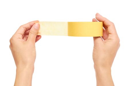Hands holding a yellow adhesive tape isolated on white background.の写真素材