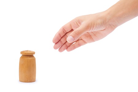 salt or paper shaker in hand isolated on white background.の写真素材
