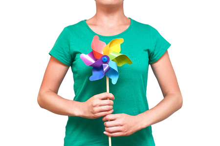 Girl hands turning paper wind mill. Isolated on white background.の写真素材