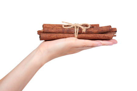 cinnamon stick spice in hand isolated on white background.の写真素材