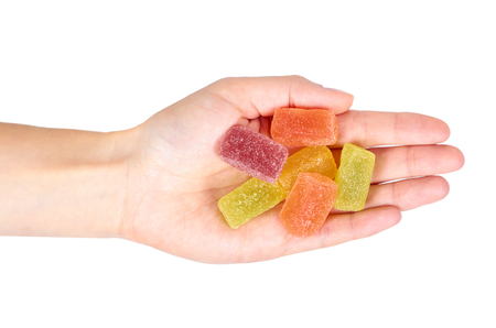 Various color of fruity gummy jelly candies in hand isolated on white background.の写真素材