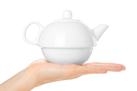white ceramic tea pot in hand isolated on white background.の写真素材