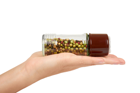 hand with glass pepper mill isolated on white background, hot and spicy flavor.の写真素材