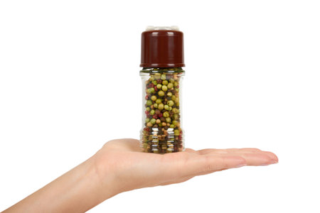 hand with glass pepper mill isolated on white background, hot and spicy flavor.の写真素材