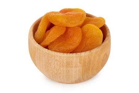 delicious and healthy dried apricots in wooden bowl isolated on white background, healthy sweet snack.の写真素材
